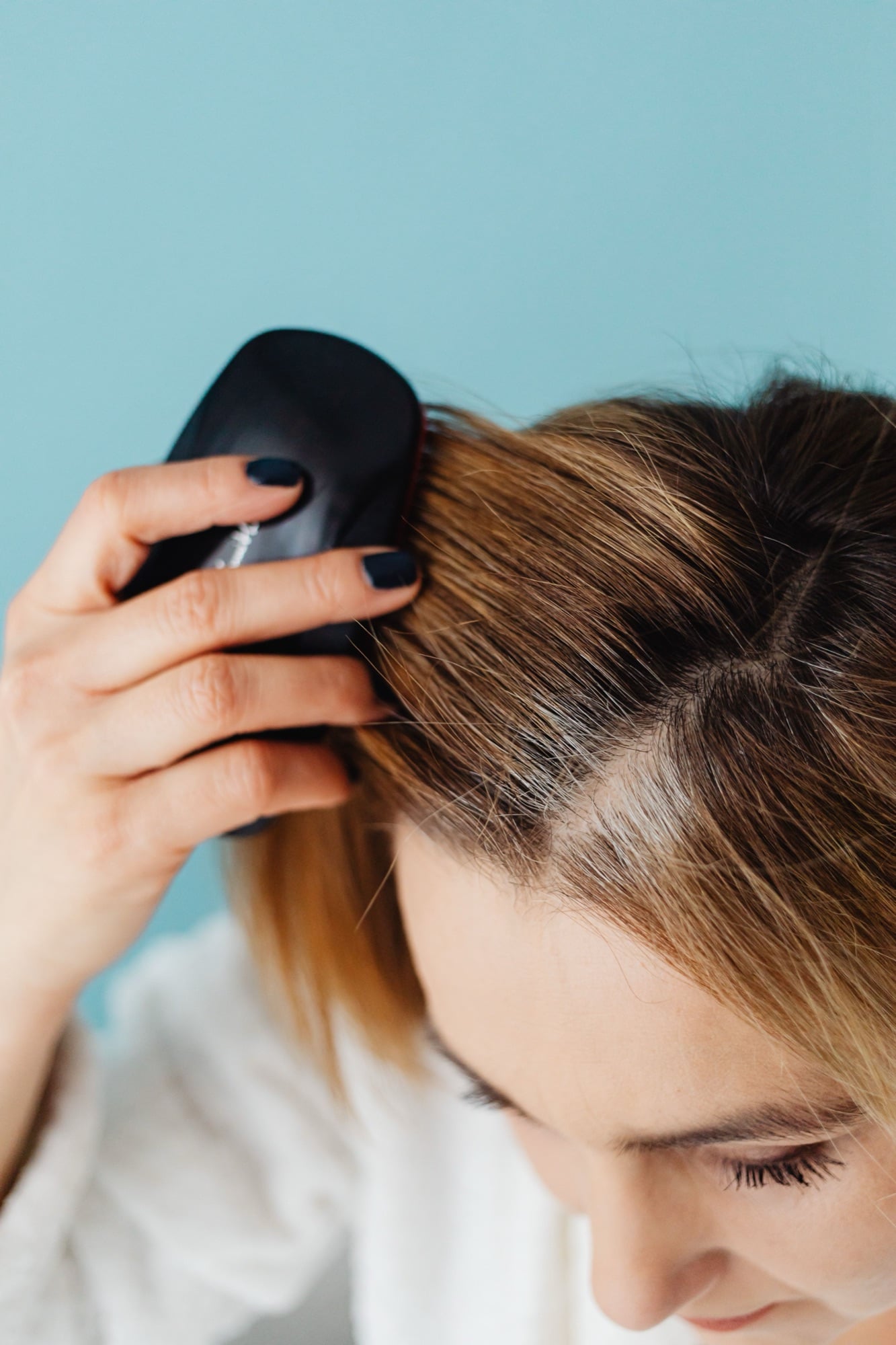 Femme qui brosse ses cheveux, la raie bien visible